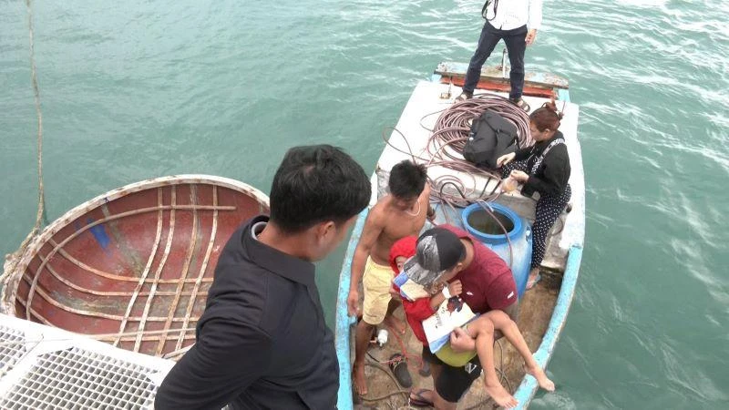 Đưa bệnh nhân mắc sốt huyết từ ghe nhỏ ra tàu cao tốc để chuyển vào đất liền cấp cứu.