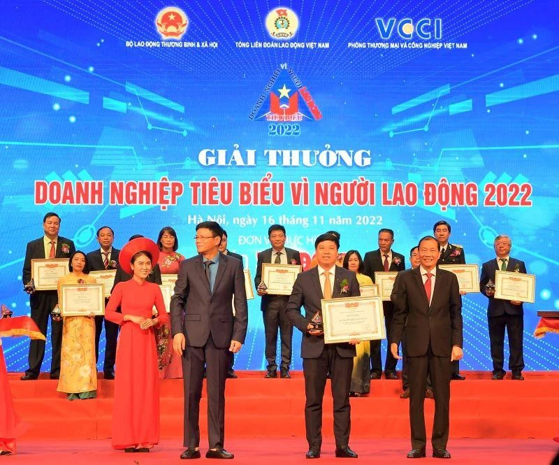 Ông Hoàng Quang Phòng - Phó Chủ tịch VCCI (bên phải) trao Bằng khen “Doanh nghiệp tiêu biểu vì người lao động” của VCCI và Ông Nguyễn Ngọc Hiển - Ủy viên Đoàn Chủ tịch Tổng Liên đoàn Lao động Việt Nam, Tổng Biên tập Báo Lao Động (bên trái) tặng Kỷ niệm chương cho ông Hồng Quang - Thành viên HĐQT kiêm Giám đốc Khối Nhân sự, Chủ tịch Công đoàn Vietcombank - đại diện Vietcombank.