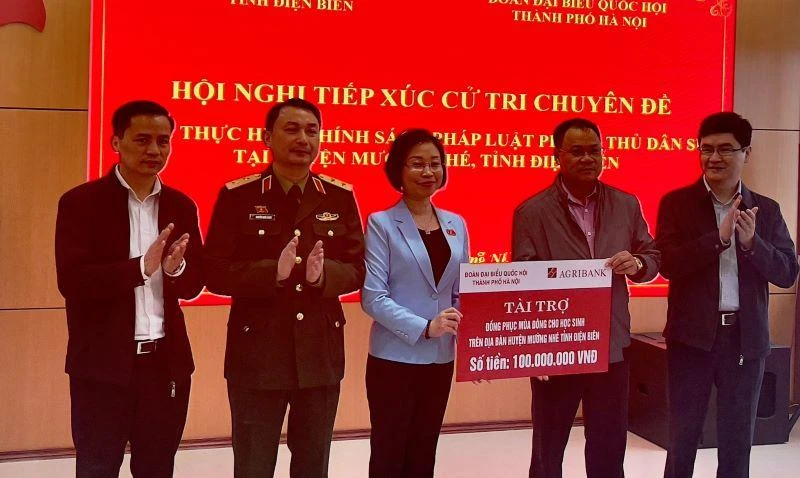 Bà Phạm Thị Thanh Mai, Phó trưởng đoàn chuyên trách Đoàn Đại biểu Quốc hội thành phố Hà Nội, trao kinh phí mua áo ấm tặng học sinh nghèo huyện Mường Nhé.