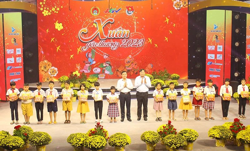 Phó Bí thư Thường trực Tỉnh ủy, Chủ tịch Hội đồng nhân dân tỉnh Hậu Giang Trần Văn Huyến (bên trái) và Phó Giáo sư, tiến sĩ Nguyễn Quốc Dũng, Giám đốc Học viện Chính trị khu vực II, trao quà cho các cháu.