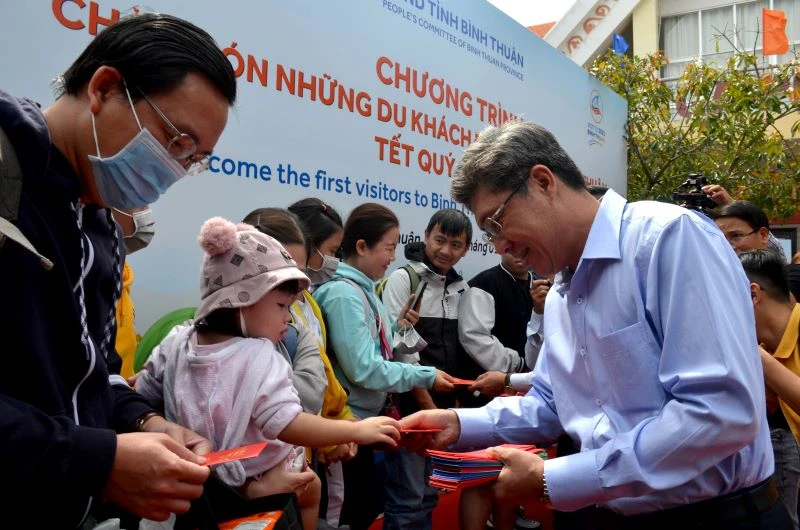Ông Nguyễn Minh, Phó Chủ tịch Ủy ban nhân dân tỉnh Bình Thuận trao tận tay những phong bao lì xì cho hành khách vừa xuống tàu.