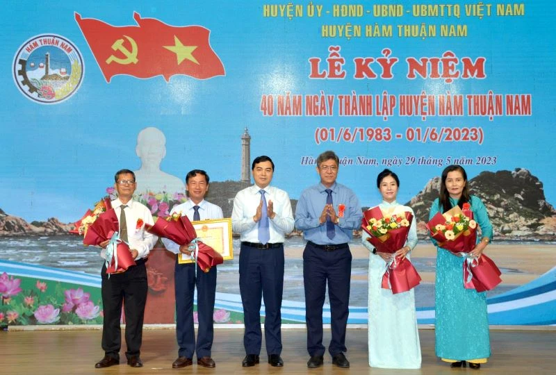Đại diện lãnh đạo tỉnh Bình Thuận trao Bằng khen của Chủ tịch Ủy ban nhân dân tỉnh và tặng hoa chúc mừng cán bộ, nhân dân huyện Hàm Thuận Nam.