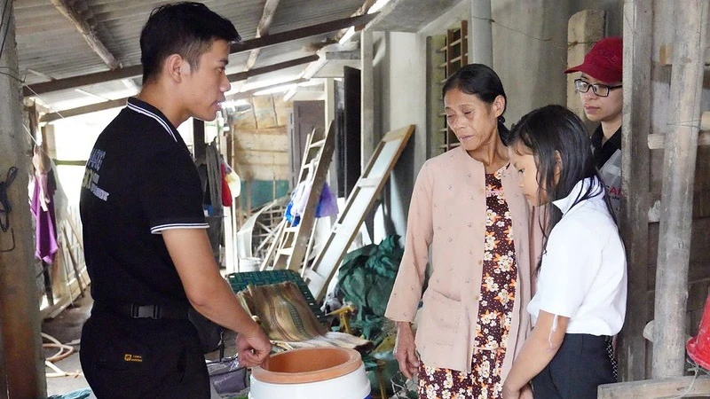 Nhân viên USAID (trái) hỗ trợ người khuyết tật bị ảnh hưởng bởi lũ lụt ở Việt Nam. (Ảnh: USAID)