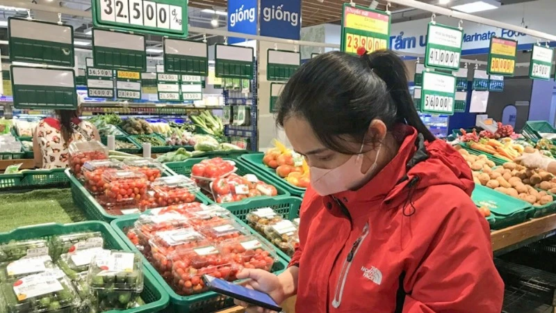 Người tiêu dùng kiểm tra thông tin, nguồn gốc hàng hóa thông qua việc quét mã QR tại một siêu thị ở thành phố Buôn Ma Thuột, tỉnh Đắk Lắk. (Ảnh: ĐỖ LAN)