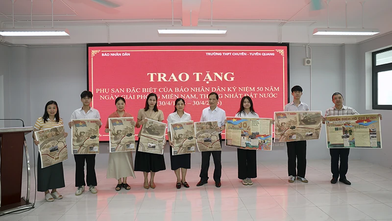 Trưởng Văn phòng đại diện Báo Nhân Dân tại Tuyên Quang trao tặng phụ san đặc biệt cho thầy, cô giáo và các em học sinh trường THPT Chuyên Tuyên Quang.