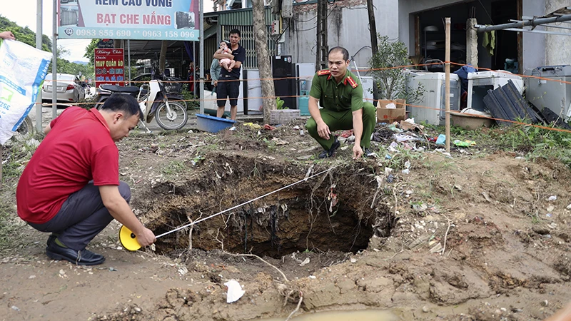 Lực lượng Công an xã Tân Thanh kiểm tra độ rộng của hố sụt lún.