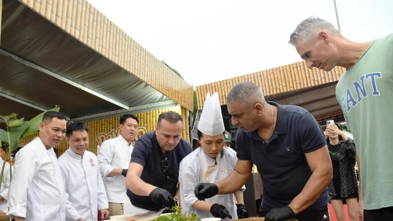 Du khách quốc tế trải nghiệm làm gỏi cá tại Lễ hội Đà Nẵng Food Tour 2025.
