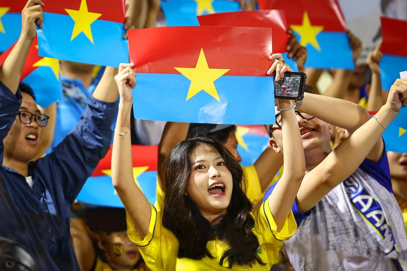Hàng nghìn cổ động viên của câu lạc bộ bóng đá Sông Lam Nghệ An mang cờ của Mặt trận Dân tộc Giải phóng miền Nam Việt Nam đến sân vận động Thống Nhất (Thành phố Hồ Chí Minh) để chào mừng 50 năm Ngày thống nhất đất nước. Ảnh: Khoa Nguyễn
