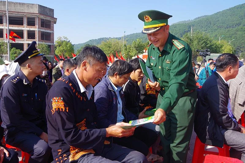 Cán bộ Đồn Biên phòng cửa khẩu Chi Ma (Lộc Bình) phát tờ rơi cho bà con sinh sống tại khu vực cửa khẩu.