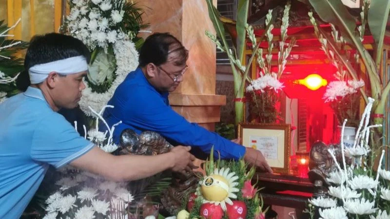 Bí thư Tỉnh đoàn Thái Bình Thiệu Minh Quỳnh đặt Huy hiệu "Tuổi trẻ dũng cảm" trước di ảnh Trung úy công an Đỗ Văn Tú. (Ảnh: Tỉnh đoàn Thái Bình cung cấp)