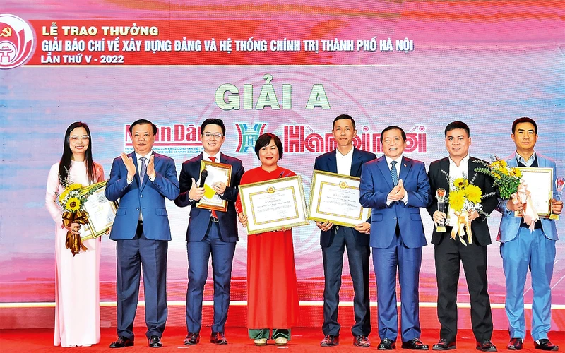 Bí thư Thành ủy Ðinh Tiến Dũng và Phó Trưởng Ban Thường trực Ban Tuyên giáo Trung ương Lại Xuân Môn trao Giải A cho các tác giả đoạt giải. (Ảnh Thủy Nguyên)