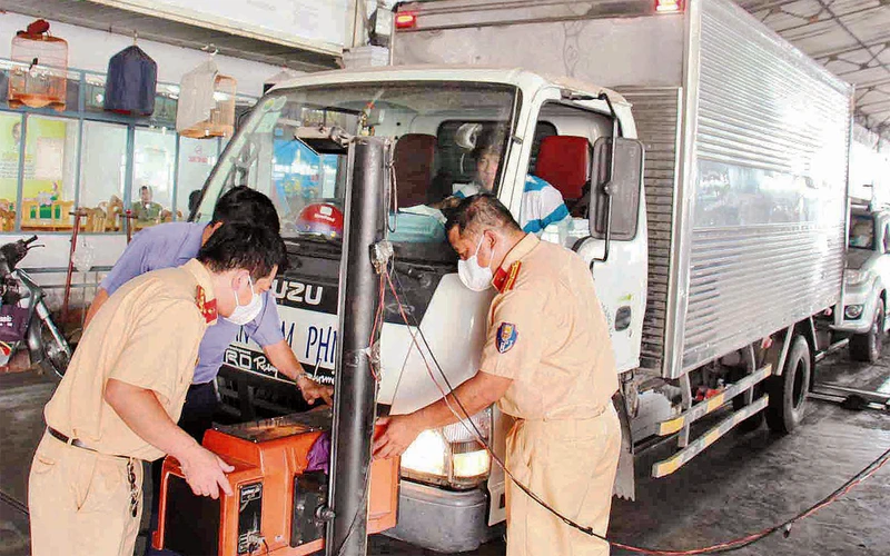 Cán bộ, chiến sĩ Cảnh sát giao thông tăng cường hỗ trợ đăng kiểm phương tiện tại Trung tâm đăng kiểm 50.03S (phường Hiệp Bình Chánh, thành phố Thủ Ðức). (Ảnh THẾ ANH)