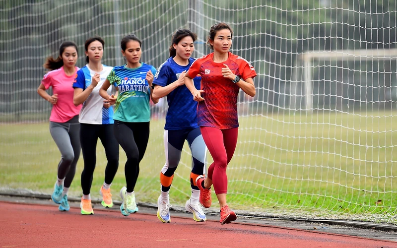 Nguyễn Thị Oanh (áo đỏ) cùng Ðội tuyển điền kinh tập luyện chuẩn bị cho SEA Games 32. (Ảnh MỸ HÀ)