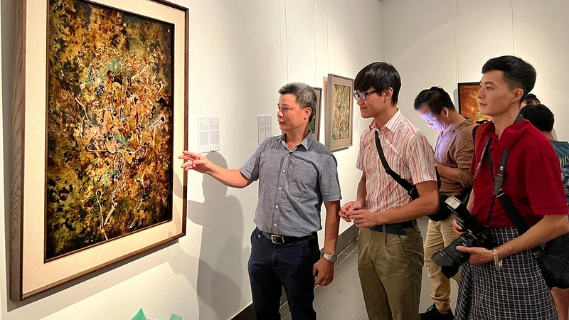 Họa sĩ Triệu Khắc Tiến giới thiệu tác phẩm sơn mài trên vóc “Hoan ca”. 