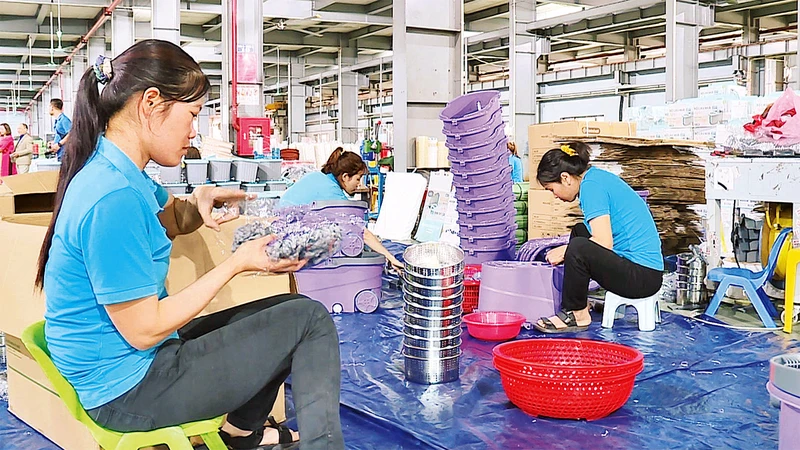 Người lao động tại Công ty TNHH sản xuất nhựa Việt Nhật (huyện Thanh Oai) bắt tay ngay vào công việc từ những ngày đầu xuân. (Ảnh DUY LINH)