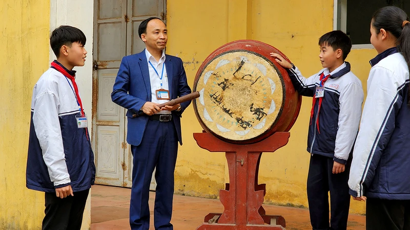 Thầy giáo Nguyễn Văn Ngọc trao đổi với học sinh về mô hình “Tiếng trống học bài”.