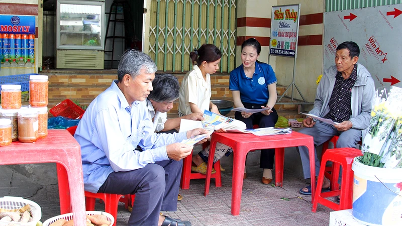 Cán bộ bảo hiểm xã hội tỉnh phối hợp địa phương tuyên truyền cho người lao động tham gia bảo hiểm xã hội tự nguyện.