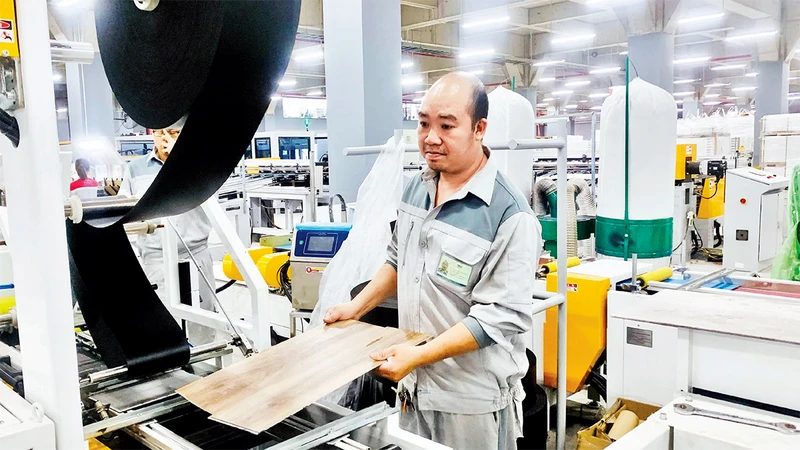 Sản xuất sản phẩm sàn đá công nghệ SPC tại Công ty Pha Lê Plastics (Khu công nghiệp MP Ðình Vũ, Hải Phòng).