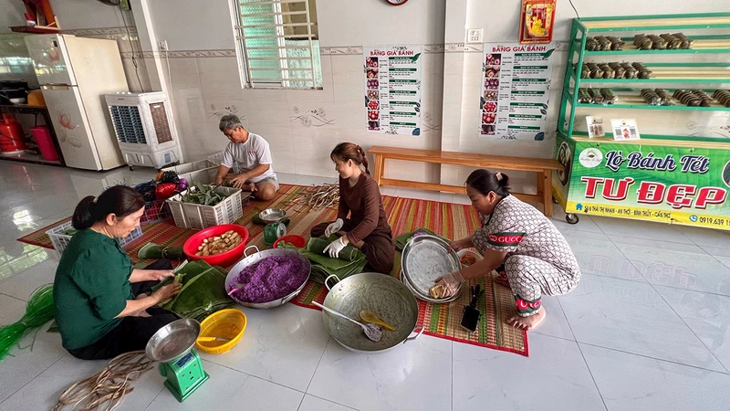 Bà Tư Ðẹp (ngoài cùng bên trái) cùng gia đình kế thừa và phát triển nghề làm bánh tét hơn 50 năm qua tại Cần Thơ.