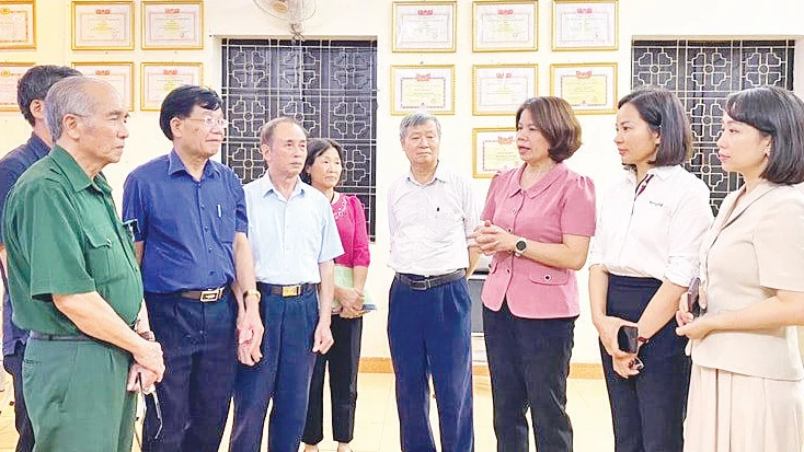 Ban Tổ chức Quận ủy Long Biên trao đổi với cán bộ, đảng viên phường Bồ Ðề về kinh nghiệm ứng dụng “Sổ tay đảng viên điện tử” vào sinh hoạt định kỳ. (Ảnh HÀ VŨ)