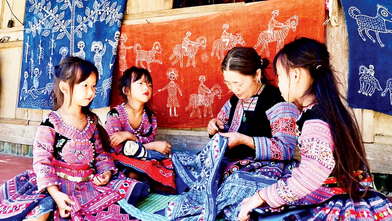 Người dân tộc H’Mông ở xã Pà Cò truyền nghề dệt thổ cẩm cho thế hệ trẻ. 