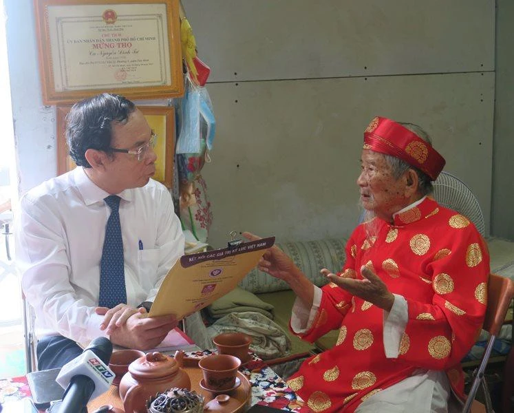 Đồng chí Nguyễn Văn Nên (bên trái) thăm hỏi, chúc thọ Nhà nghiên cứu văn hóa Nguyễn Đình Tư.