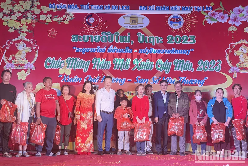 Ban Tổ chức trao quà cho kiều bào có hoàn cảnh khó khăn. (Ảnh: Hải Tiến)