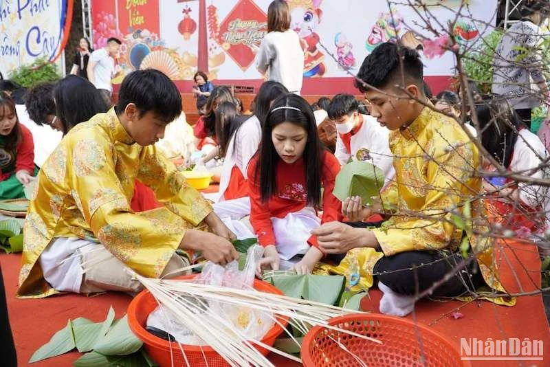 Học sinh cùng nhau gói bánh chưng trong lễ hội Xuân ở trường học