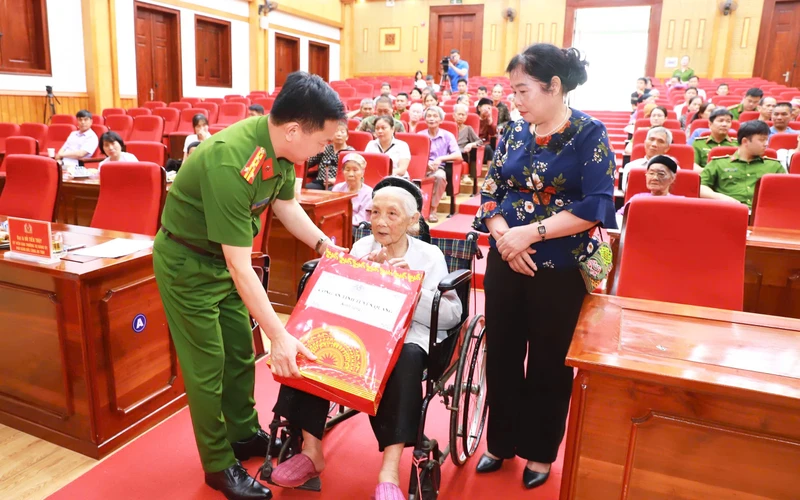 Đại tá Đỗ Tiến Thùy, Phó Giám đốc Công an tỉnh Tuyên Quang tặng quà Mẹ Việt Nam Anh hùng, mẹ liệt sĩ tham gia lấy mẫu.