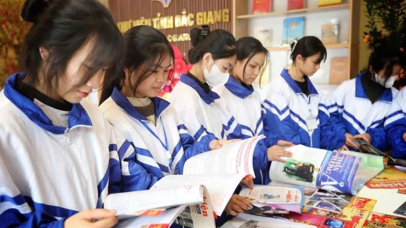 Các em học sinh đọc sách tại gian trưng bày chào mừng 50 năm Ngày Giải phóng miền nam, thống nhất đất nước tại Thư viện Bắc Giang.