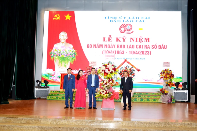 Phó Tổng Biên tập Báo Nhân Dân Đinh Như Hoan tặng hoa và chúc mừng Ban Biên tập Báo Lào Cai, nhân kỷ niệm 60 năm ngày Báo Lào Cai ra số đầu. (Ảnh: Quốc Hồng)