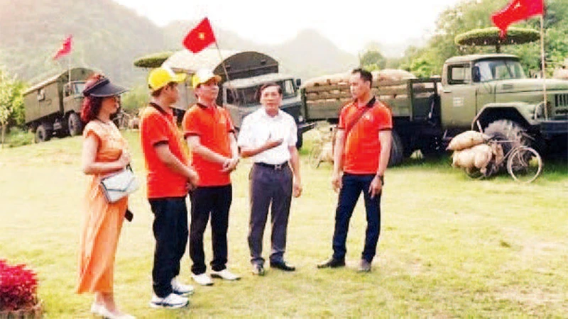 Cựu chiến binh Phạm Công Chất (thứ hai từ phải sang) hướng dẫn nhân viên kỹ thuật tại Khu du lịch sinh thái Thung Nham. (Ảnh TRẦN LAN)