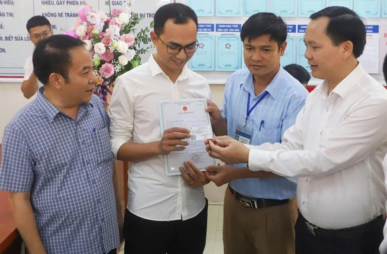 Anh Đinh Tiến Hoàng (huyện Thanh Liêm) nhận giấy khai sinh và thẻ bảo hiểm y tế cho con mới sinh, khi thí điểm hai thủ tục hành chính liên thông tại tỉnh Hà Nam, tháng 11/2022 (Ảnh: Trung Tâm)