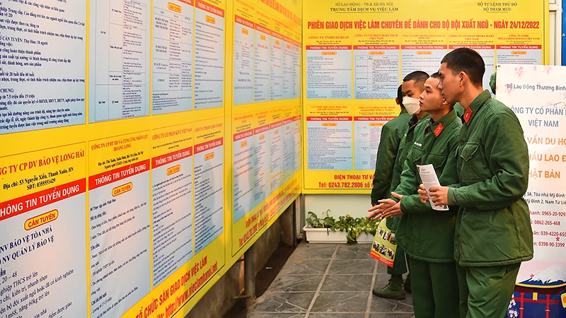 Các quân nhân sắp hoàn thành nghĩa vụ quân sự tìm hiểu thông tin tại phiên giao dịch việc làm. (Ảnh: THỦY NGUYÊN).