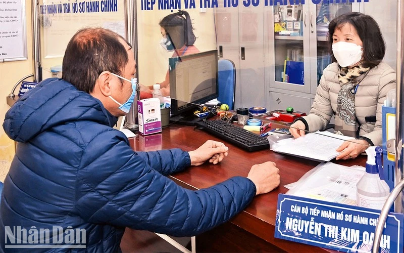 Cán bộ tại Bộ phận “một cửa” UBND phường Nguyễn Du, quận Hai Bà Trưng, giải quyết thủ tục hành chính cho người dân. (Ảnh: Đăng Duy) 