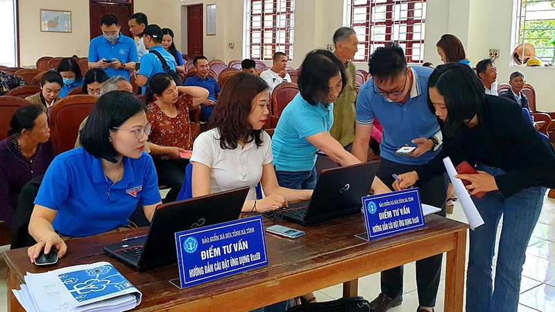 Cán bộ bảo hiểm xã hội hướng dẫn người dân cài đặt VssID. (Ảnh: Tâm Trung)