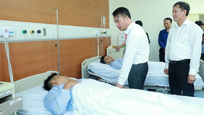 Tổng Giám đốc Bảo hiểm xã hội Việt Nam Nguyễn Thế Mạnh, Giám đốc Bảo hiểm xã hội Hà Nội thăm hỏi nạn nhân vụ cháy. (Ảnh: Khánh Duy)