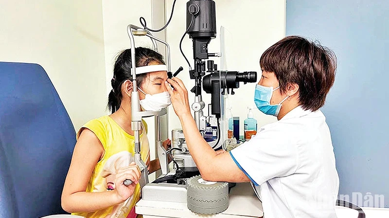 Bác sĩ Bệnh viện Mắt Hà Nội 2 thăm khám cho bệnh nhi. (Ảnh: nhandan.vn)