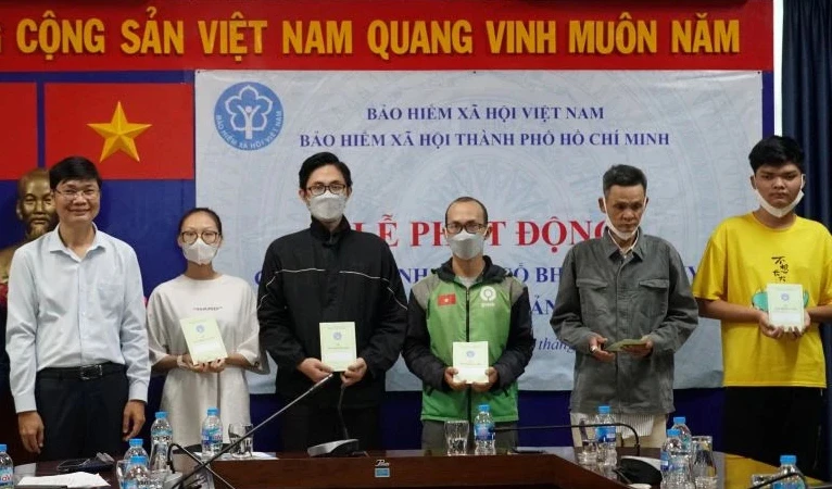 Trao thẻ bảo hiểm y tế, sổ bảo hiểm xã hội cho người dân có hoàn cảnh khó khăn, diện chính sách trên địa bàn Thành phố Hồ Chí Minh. (Ảnh: HSS)