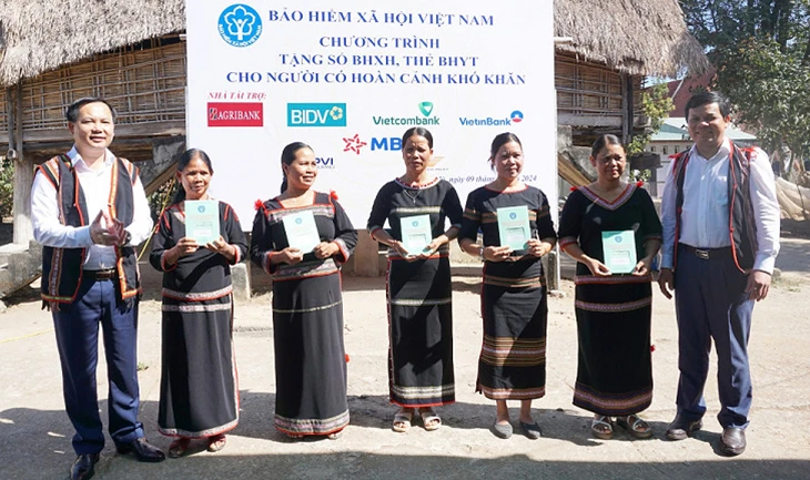 Phó Tổng Giám đốc Bảo hiểm xã hội Việt Nam Chu Mạnh Sinh trao sổ bảo hiểm xã hội, thẻ bảo hiểm y tế tặng người dân xã Đăk La, huyện Đăk Hà, Kon Tum. (Ảnh: KSS)