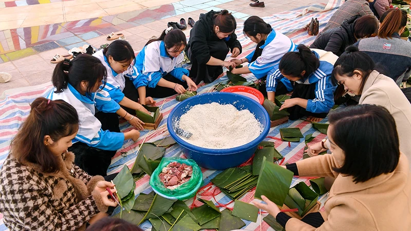 Học sinh trường Phổ thông Dân tộc nội trú, Trung học phổ thông Nậm Pồ gói bánh chưng gửi đồng bào nghèo vùng biên viễn Điện Biên. Ảnh: THÀNH ĐẠT