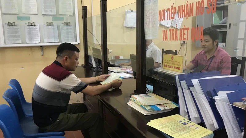 Cán bộ thực hiện giải quyết thủ tục hành chính tại xã Đồng Phú, huyện Chương Mỹ, Hà Nội. (Ảnh: nhandan.vn)