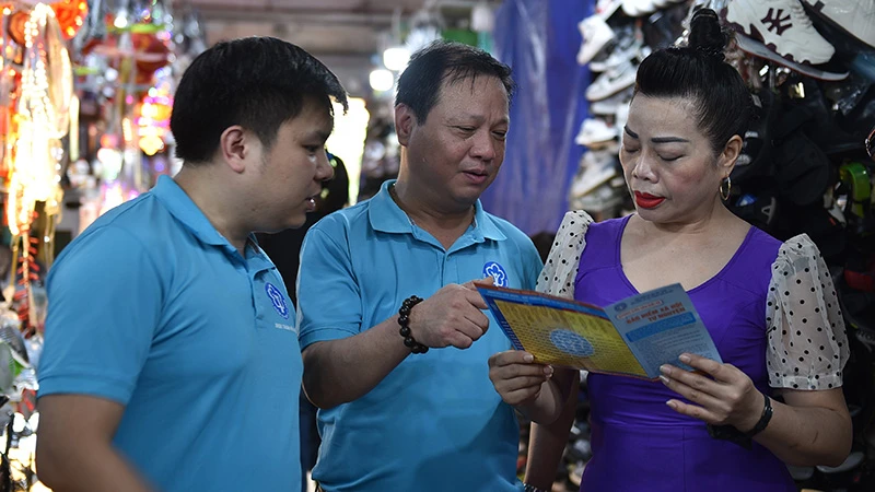 Cán bộ Bảo hiểm xã hội khu vực I ra quân vận động người dân tham gia bảo hiểm xã hội, bảo hiểm y tế hộ gia đình. (Ảnh: HSS)