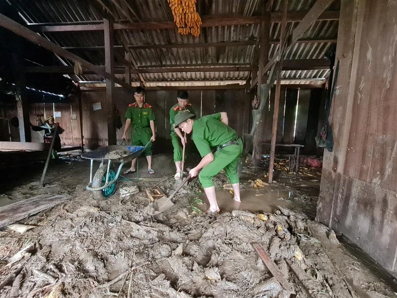 Công an huyện Than Uyên (Lai Châu) giúp dân xúc bỏ bùn đất tràn vào nhà tại bản Hô Ta, xã Tà Mung.
