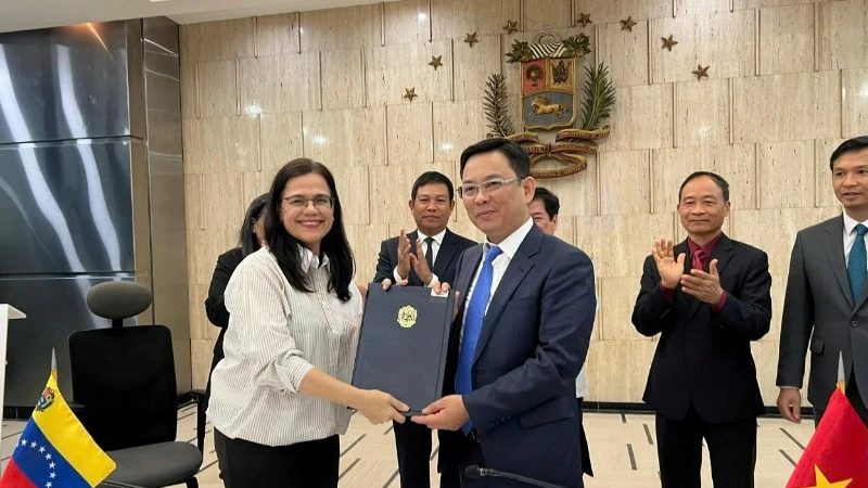 Phó Chủ tịch Liên hiệp các tổ chức hữu nghị Việt Nam Đồng Huy Cương và Chủ tịch Viện Simon Bolivar vì Hòa bình và Đoàn kết giữa các dân tộc Rosa Eekhout Gómez ký kết Bản ghi nhớ hợp tác. (Ảnh: Đại sứ quán Việt Nam tại Venezuela)