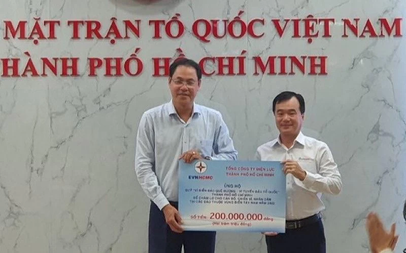 Ông Trần Vũ Quang, Trưởng Ban Kiểm tra - Thanh tra EVNHCMC (bên phải) trao số tiền 200 triệu đồng cho Quỹ “Vì biển đảo quê hương-Vì tuyến đầu Tổ quốc”.