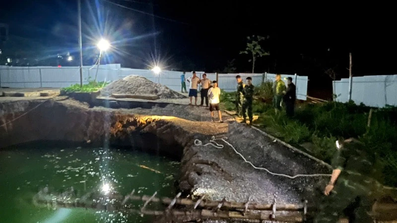Lực lượng chức năng và người dân tìm kiếm tại khu vực hố sụt trong đêm 26/7. (Ảnh: TUẤN SƠN).