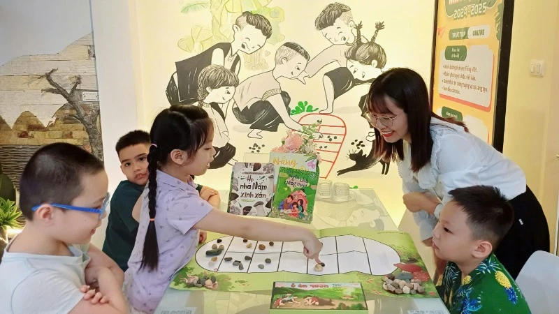 Các bạn nhỏ chơi trò ô ăn quan cùng cô giáo.