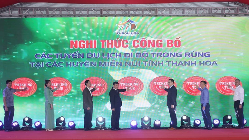 Các đại biểu thực hiện nghi thức khai trương tuyến du lịch đi bộ trong rừng.