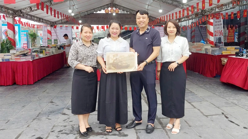 Đại diện Văn phòng Báo Nhân Dân tại Quảng Ninh tặng phụ san đặc biệt "Chiến dịch Hồ Chí Minh" cho bạn đọc.